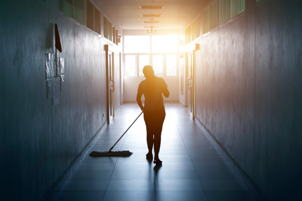 woman mopping floor in hallway office building 