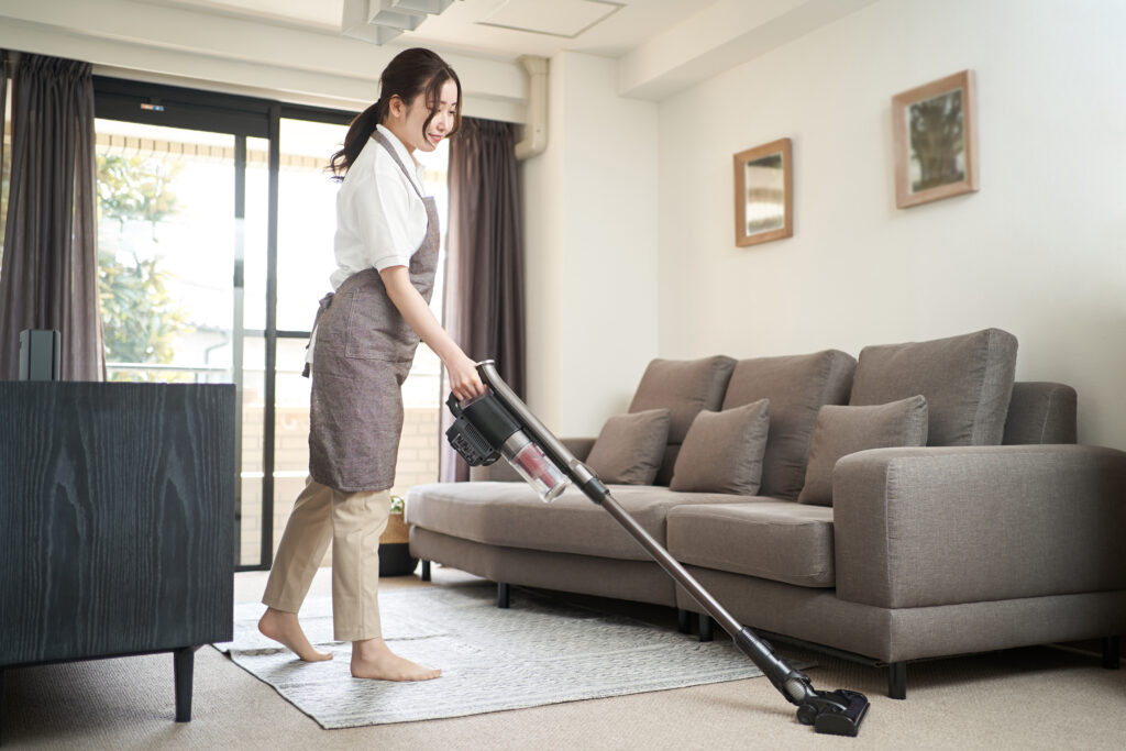 Asian woman vacuuming in the living room